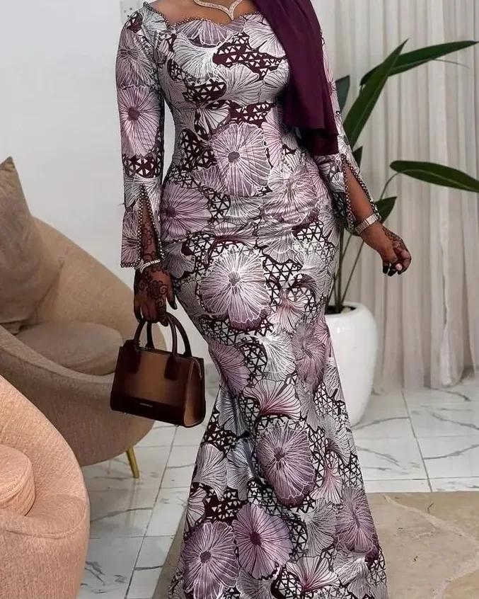 A woman in a mauve and grey Ankara mermaid gown with a matching gele, in a luxe interior
